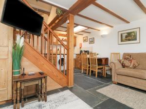 a living room with a couch and a tv at Mole Cottage in Liskeard