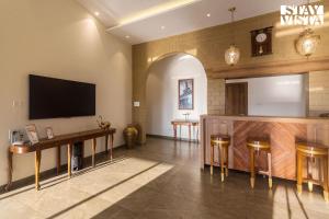a large room with a tv on the wall at StayVistas Nyra Farms - Hill-view villa with Pool, Indoor & Outdoor games, & Lawn with Gazebo in Wada
