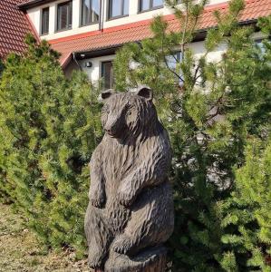 une statue d'ours devant quelques buissons dans l'établissement Hotel Karupesa, à Otepää