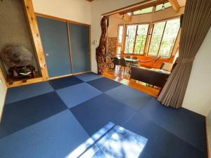 スイートヴィラ NASU四季リゾート في ناسو: غرفة معيشة مع أرضية من البلاط الأزرق