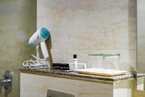 a bathroom counter with a blow dryer on it at Saltstayz Executive Studio Apartment in Gurgaon