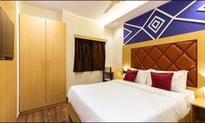 a bedroom with a large white bed with red pillows at FabHotel Green House in Mumbai