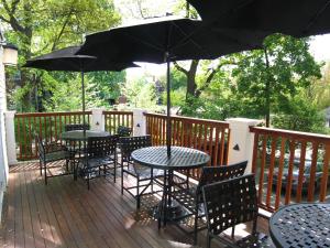 a patio area with tables, chairs and umbrellas at Longwood Inn in Brookline