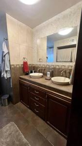 a bathroom with two sinks and a large mirror at Casa Maya in Mexicali