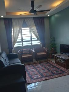 ein Wohnzimmer mit einem Sofa und einem TV in der Unterkunft D'Kayangan KTcity Seaview Homestay in Kuala Terengganu