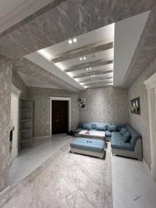NEW Apartment في طشقند: غرفة معيشة كبيرة مع أريكة زرقاء في غرفة