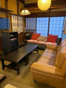 sala de estar con sofá y mesa de centro en 民泊Azoo, en Gujō