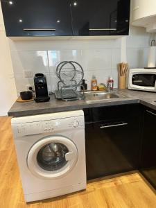 a kitchen with a washing machine and a sink at La sapinière in Troyes +18 photos