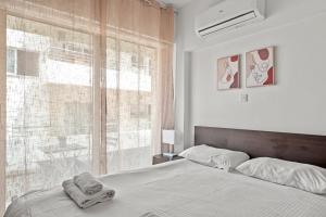 - une chambre avec un lit et une grande fenêtre dans l'établissement Downtown 2 Bedroom Apartment, à Larnaka