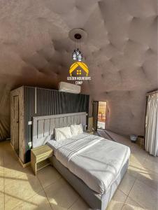 a bedroom with a large bed and a chandelier at Golden mountains camp in Wadi Rum