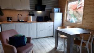 a kitchen with a table and chairs and a refrigerator at Domus Mare Tiny House 2 in Wisełka
