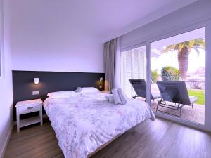 une chambre avec un grand lit et une grande fenêtre dans l'établissement Tropicalidays Botanic Garden, à Puerto de la Cruz 40 autres photos