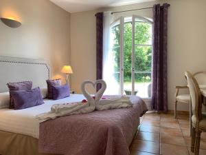 Un dormitorio con una cama con dos cisnes. en Hôtel La Bastide Saint Martin, en Carcassonne