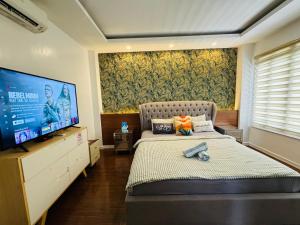 a bedroom with a bed and a flat screen tv at Villa Amihan in Puerto Galera +39 photos