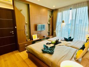 チェンマイにあるThe Astra Condo Chiang Maiのベッドが2つと大きな窓がある寝室