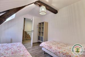 a bedroom with white walls and a bed and a window at Youwen in Saint-Brice-en-Coglès