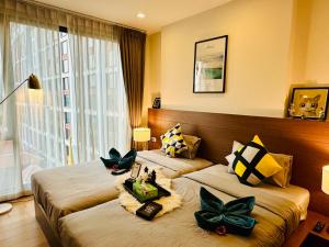 チェンマイにあるThe Astra Condo Chiang Maiのホテルルーム 花の飾られたベッド2台付 +137枚の写真