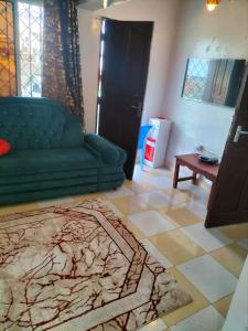 a living room with a green couch and a table at Olympic Lamu sea front house - 2 bedroom All ensuite in Lamu