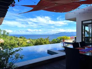 uma casa com uma piscina com vista para o oceano em Villa Amihan em Puerto Galera