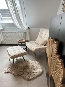 a living room with a couch and a chair and a rug at Deluxe Apartment in Duisburg