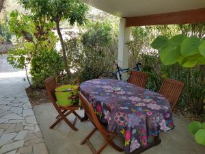 a table and chairs on a patio with a table and a bike at Maison complète Cap d'Agde au calme avec jardin in Cap d'Agde
