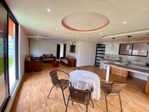 a living room with a table and chairs and a couch at Villa Mirlo – Escondite de Lujo en Quito in Quito