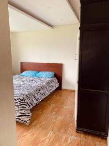 ein Schlafzimmer mit einem Bett mit blauen Kissen darauf in der Unterkunft Villa Mirlo – Escondite de Lujo en Quito in Quito