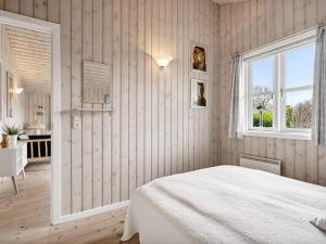 a bedroom with a white bed and a window at Holiday home Hemmet VI in Hemmet