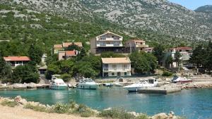 a group of boats docked in a river with houses at Sweet house with garden 35 meters from sea in Karlobag