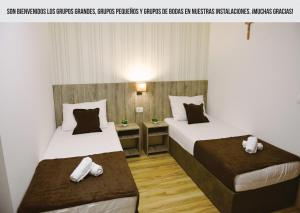 two beds in a hotel room with towels on them at Mica Medjugorje in Međugorje