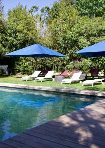 - un groupe de chaises longues et de parasols à côté de la piscine dans l'établissement A Propos - Chambres d'Hôtes, à Orange