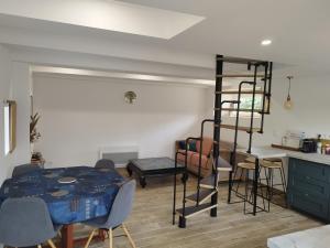 a bedroom with a bed and a kitchen with a ladder at Maison entre Dinan et Dinard in Pleslin-Trigavou