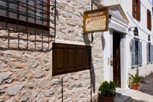 a sign for a restaurant on the side of a building at Achilleas Pension in Hydra