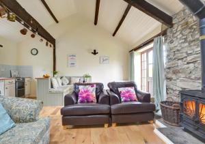 Swallow Cottage في Llanerchymedd: غرفة معيشة مع أريكة ومدفأة