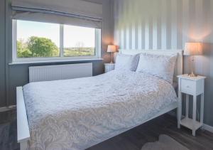 a bedroom with a white bed and a window at Erw Las in Ciliau-Aeron