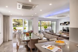 a dining room and living room with a glass table at Fig Tree Bay Residences 4 in Protaras