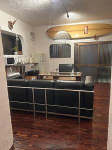 Una sala de estar con un sofá negro en una habitación. en 海と山と川、田園に囲まれた静かな古民家一棟貸し, en Miyazaki 11 fotos más