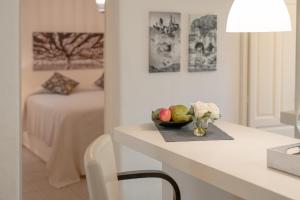 a white room with a table with a bowl of fruit at Bungalows Casa Amarilla in Playa Migjorn