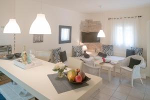 una cucina e un soggiorno con tavolo e cesto di frutta di Bungalows Casa Amarilla a Playa Migjorn