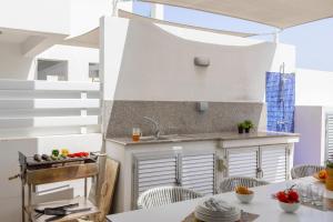a small kitchen with a sink and a table at Fig Tree Bay Residences 4 in Protaras