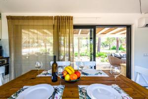 a dining room table with a bowl of fruit and wine glasses at Casa dos Sonhos in Vale do Lobo