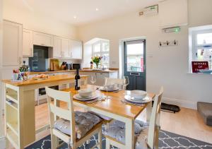 cocina y comedor con mesa de madera y sillas en 2 Railway Cottages en Selside