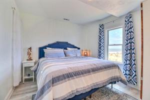 een slaapkamer met een blauw bed en een raam bij 4002 Alwright Alwright Alwright Oceanfront in Kitty Hawk