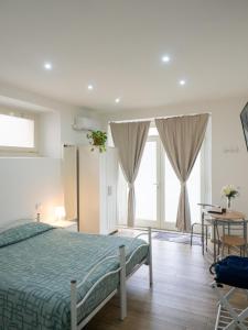 1 dormitorio con cama, mesa y ventanas en Paolessi House en Rieti