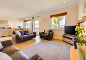 a living room with a couch and a tv at Lanngorrow in Saint Merryn