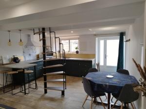cocina con mesa, mesa azul y sillas en Maison entre Dinan et Dinard, en Pleslin-Trigavou