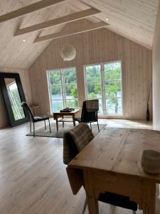 sala de estar con mesa, sillas y ventanas en Beautiful Barn Studio - Lake View en Porsgrunn