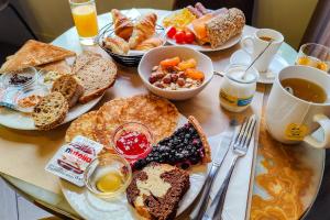 - une table avec des assiettes de produits pour le petit-déjeuner et du café dans l'établissement Hôtel de France, un hôtel AMMI, à Nice