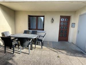 a table and chairs in front of a house at Appartement au bord du lac avec terrasse in La Tour-dʼAuvergne