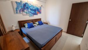 a bedroom with a bed with blue sheets and blue pillows at Aqua Vista in Uswetakeiyawa